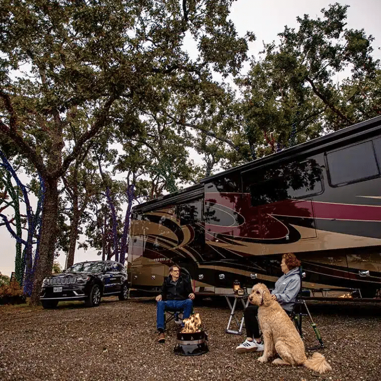 Couple sitting by a fire at Yuletide RV Park in Madisonville, TX.